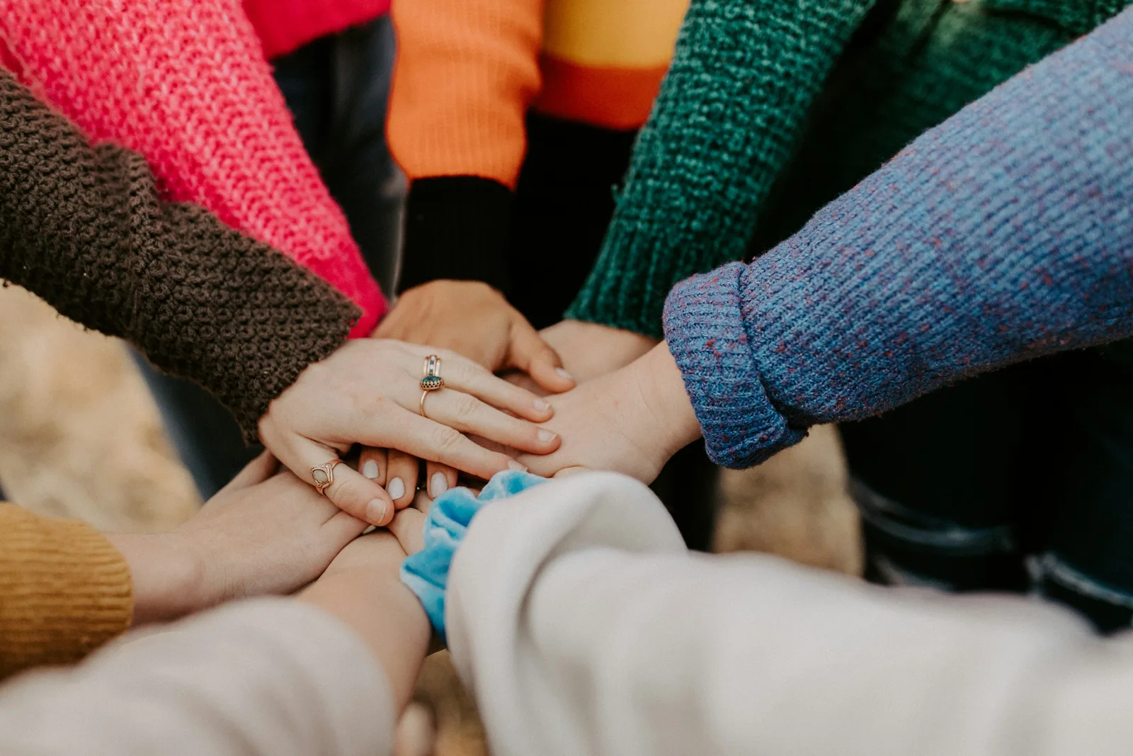 Many hands stacked together in a circle
